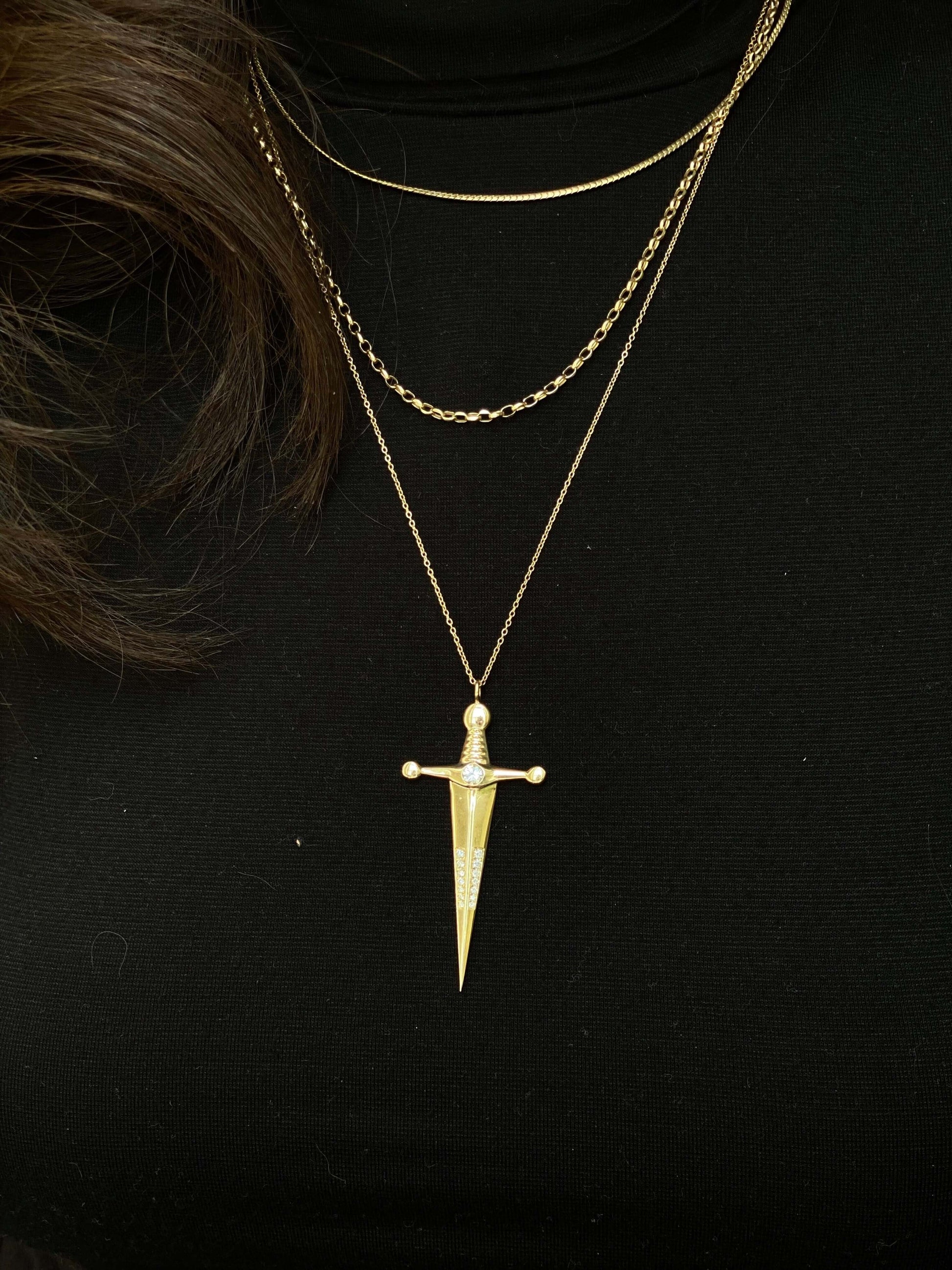 18k Gold Kelly Sword PendantA Luxe sword 18k Gold Kelly Sword Pendant for the individual wanting to make a powerful statement. Our Jewelry is proudly idealized, and produced in NYC.18k Gold Kelly Sword PendantA Luxe sword pendant for the individual wantin