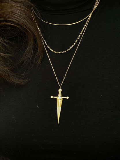 18k Gold Kelly Sword PendantA Luxe sword 18k Gold Kelly Sword Pendant for the individual wanting to make a powerful statement. Our Jewelry is proudly idealized, and produced in NYC.18k Gold Kelly Sword PendantA Luxe sword pendant for the individual wantin