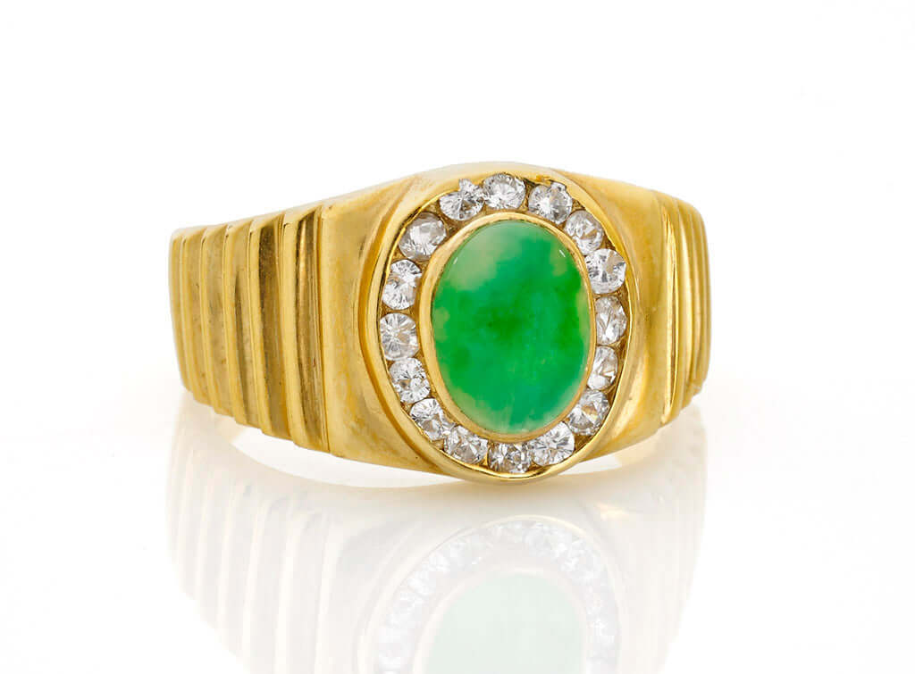 Vintage 18k Yellow Gold Jade and Diamond Ringcentering an oval jadeite cabochon of bright apple green color, surrounded by diamonds with ribbed shoulders. Can be resized. Condition: Normal antique wear Metal: 18k Yellow Gold Dimensions: Size 8Vintage 18k