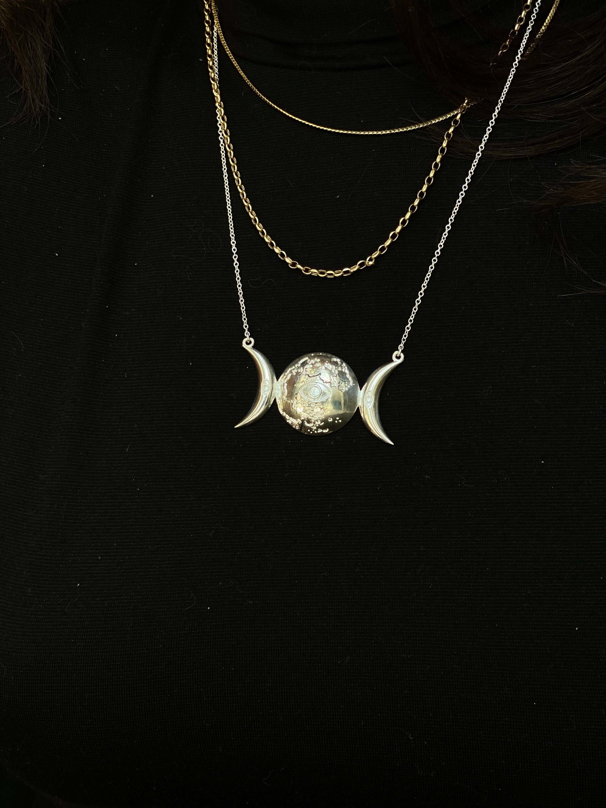 Selene PendantInspired by the Greek Goddess of the Moon, Selene, this pendant features the moon in several phases, adorned with an eye for protection. This piece can be made in sterling silver, with additional plating options for 18k Gold Vermeil. We also