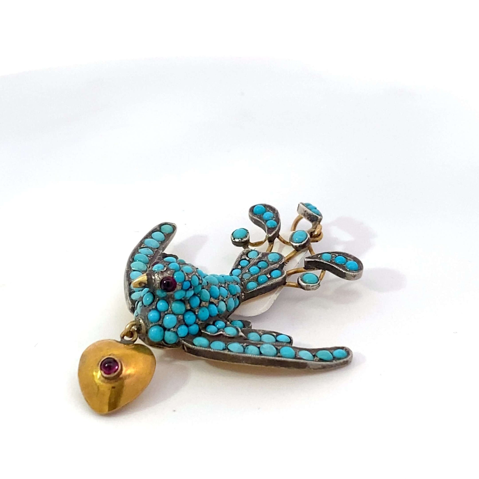 Antique Victorian Bird Pendant, low karat gold, pave turquoise, garnet eyes, hearthis exquisite pendant features a beautifully detailed bird, symbolizing freedom and love, crafted from low karat gold. The bird's body is adorned with pavé turquoise, adding