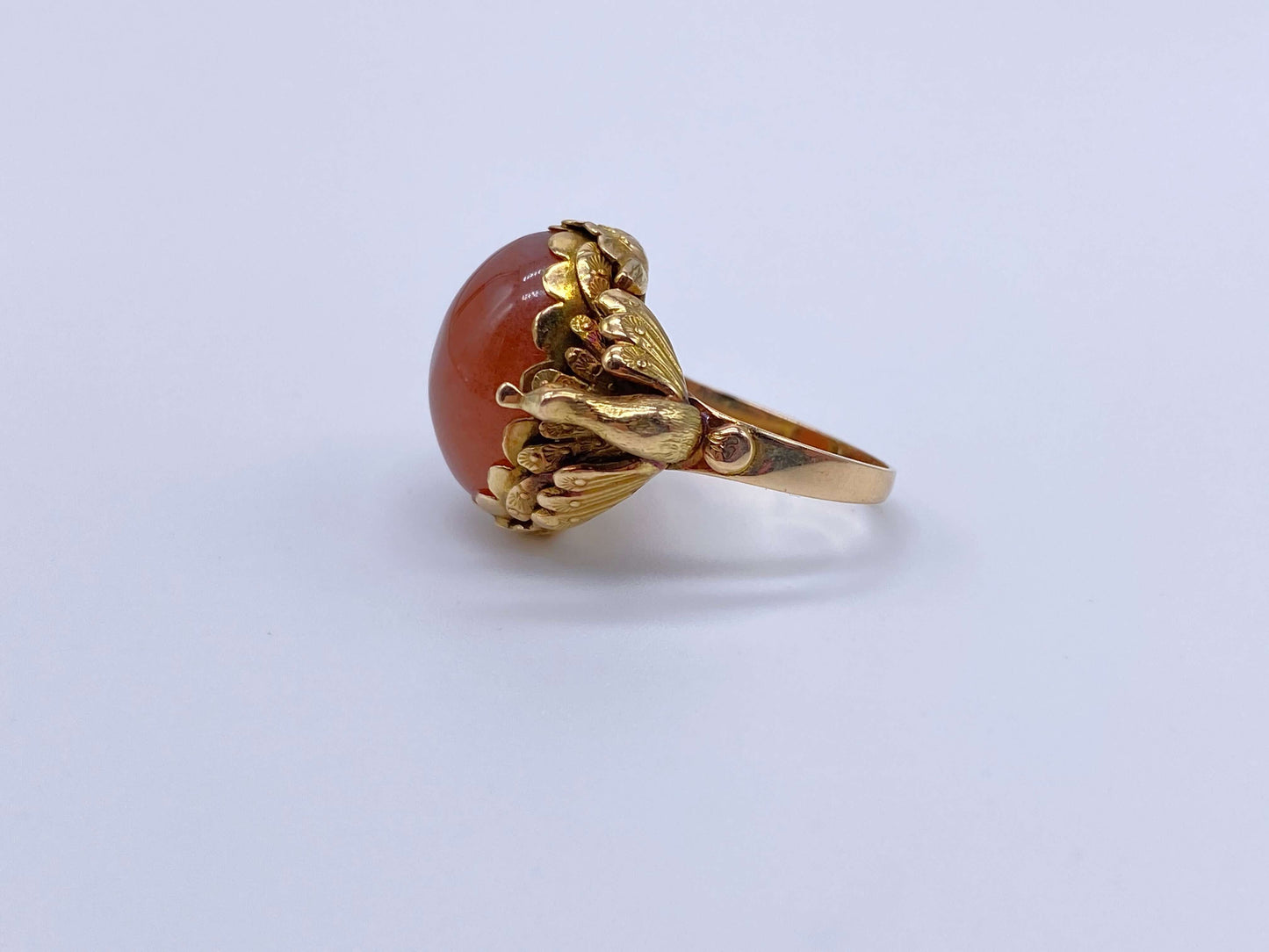 Antique Victorian Carnelian Peacock RingA gorgeous late Victorian ring with a substantial central carnelian stone. This ring has beautiful ruffled gold work around the stone. Two peacocks are suspended right above the shank. Condition: Normal antique wear