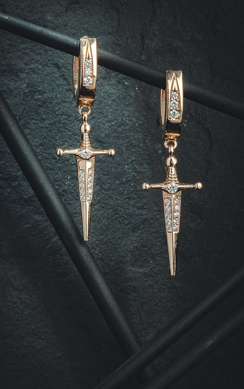 Earrings 18k Gold Kelly Sword Earrings A Pair of solid gold 18k Gold Kelly Sword Earrings that make a statement. Swords are iconic symbols of strength and these unisex earrings embody this. KIL N.Y.C.