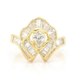Vintage 18k Ballerina Ring with Pear-Shaped Diamond and Baguette MeleeA vintage diamond ring beautifully crafted in 18k gold with a central pear shaped diamond and a lovely arrangement of baguette diamonds that glisten in all sorts of light and will sure