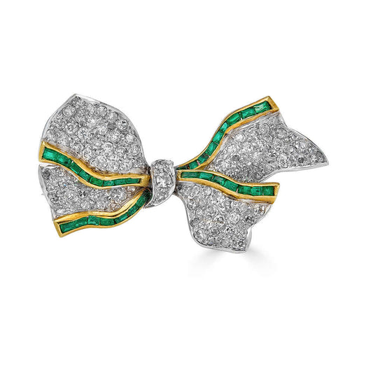 Antique Platinum Bow Brooch with Diamonds and EmeraldsA beautiful antique brooch that features a melee of gorgeous diamonds with tiny calibrated square cut emeralds that are set into 18k gold. Condition: Normal antique wear, superficial wear to the emeral